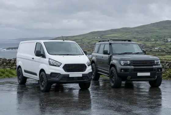 White van and a 4x4 parked on a wet Irish forecourt on chunky tyres